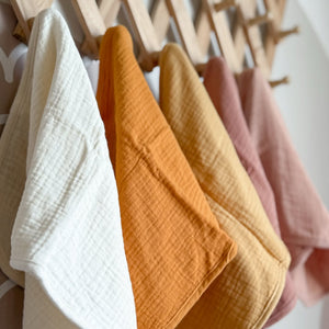Muslin Buro Cloths hanging on a rack against a white wall 