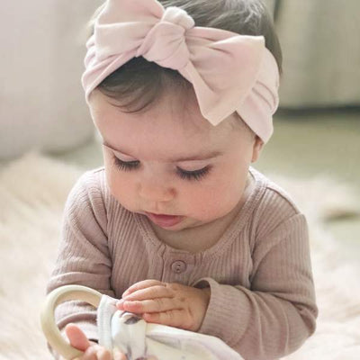 Blush pink baby bow knot headband displayed on white background by Zoe Sage
