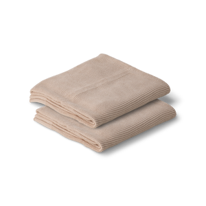 Folded beige cotton knitted baby blanket on a white background