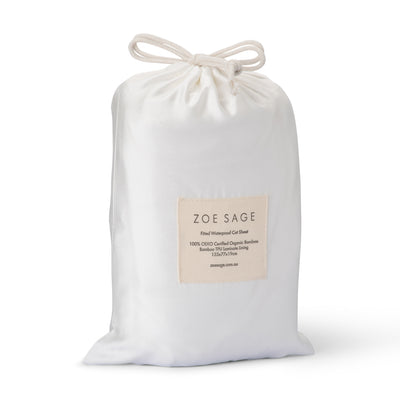 White waterproof fitted cot sheet made from organic bamboo on cot mattress.