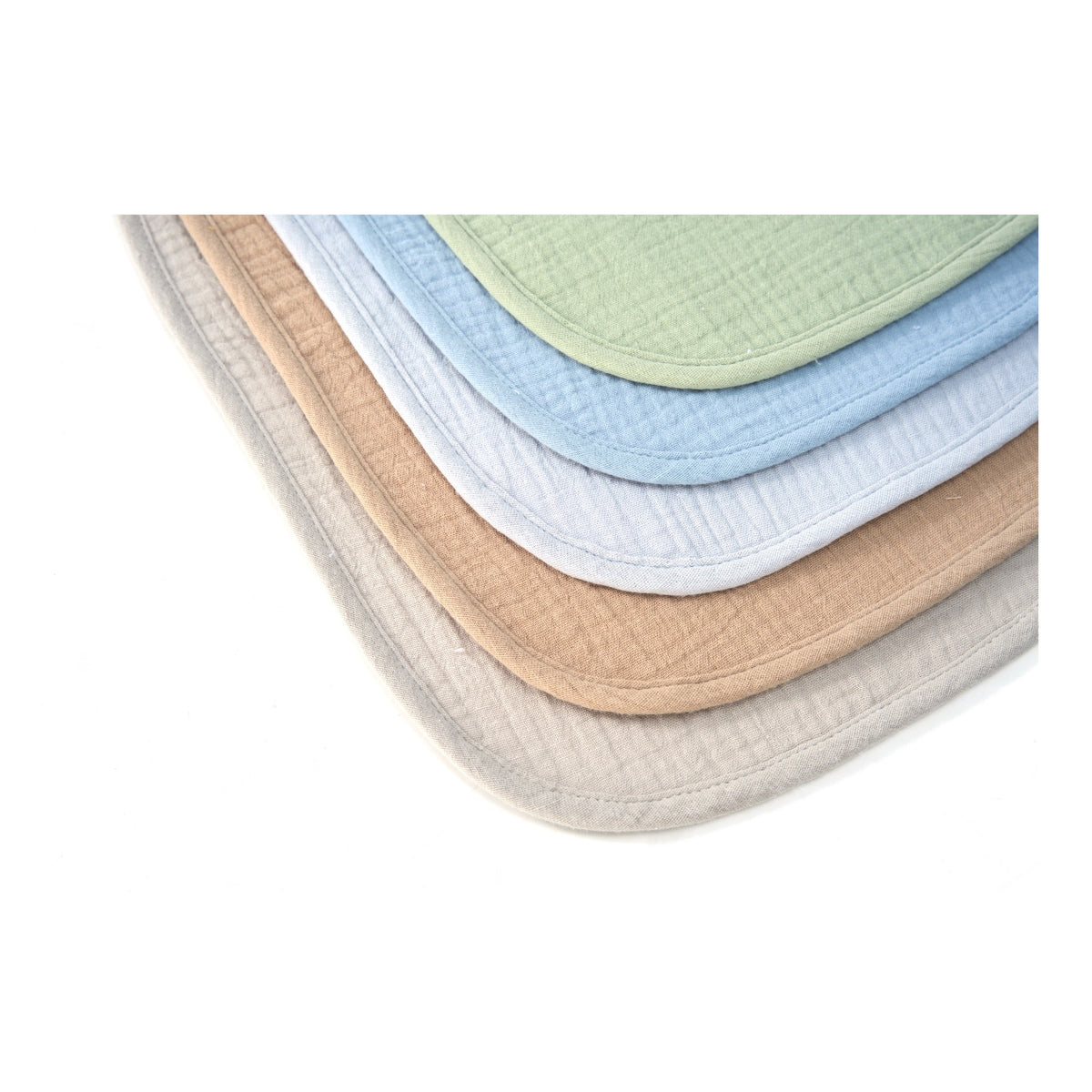 Stacked organic muslin baby bibs in Earth and Sky colours, close up of the weave