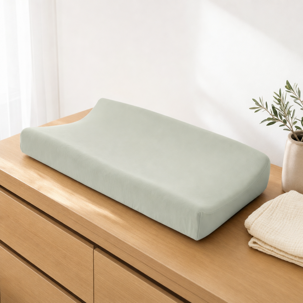 Sage waterproof bassinet sheet used as a change pad cover on a nursery dresser