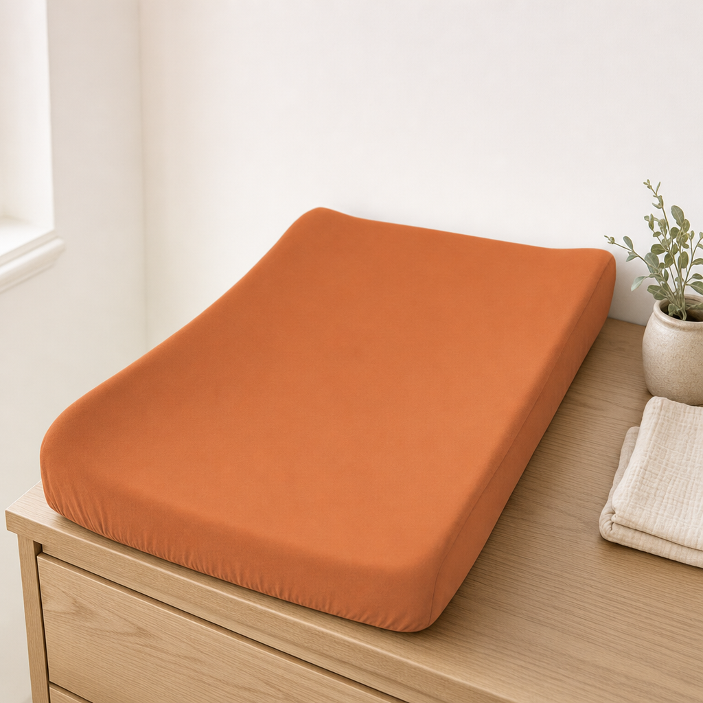 Savannah Rust waterproof bassinet sheet used as a change pad cover on a nursery dresser
