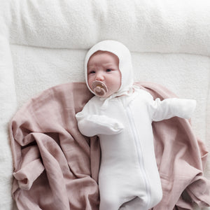 Baby laying on Muslin Swaddle Blanket | Sunset (Organic)