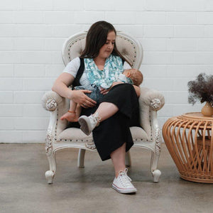 Women sitting on the sofa with his baby wearing 5 in 1 mama cover