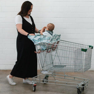 Baby sitting in  Blue Gum Leaf baby carrier in sopping cart